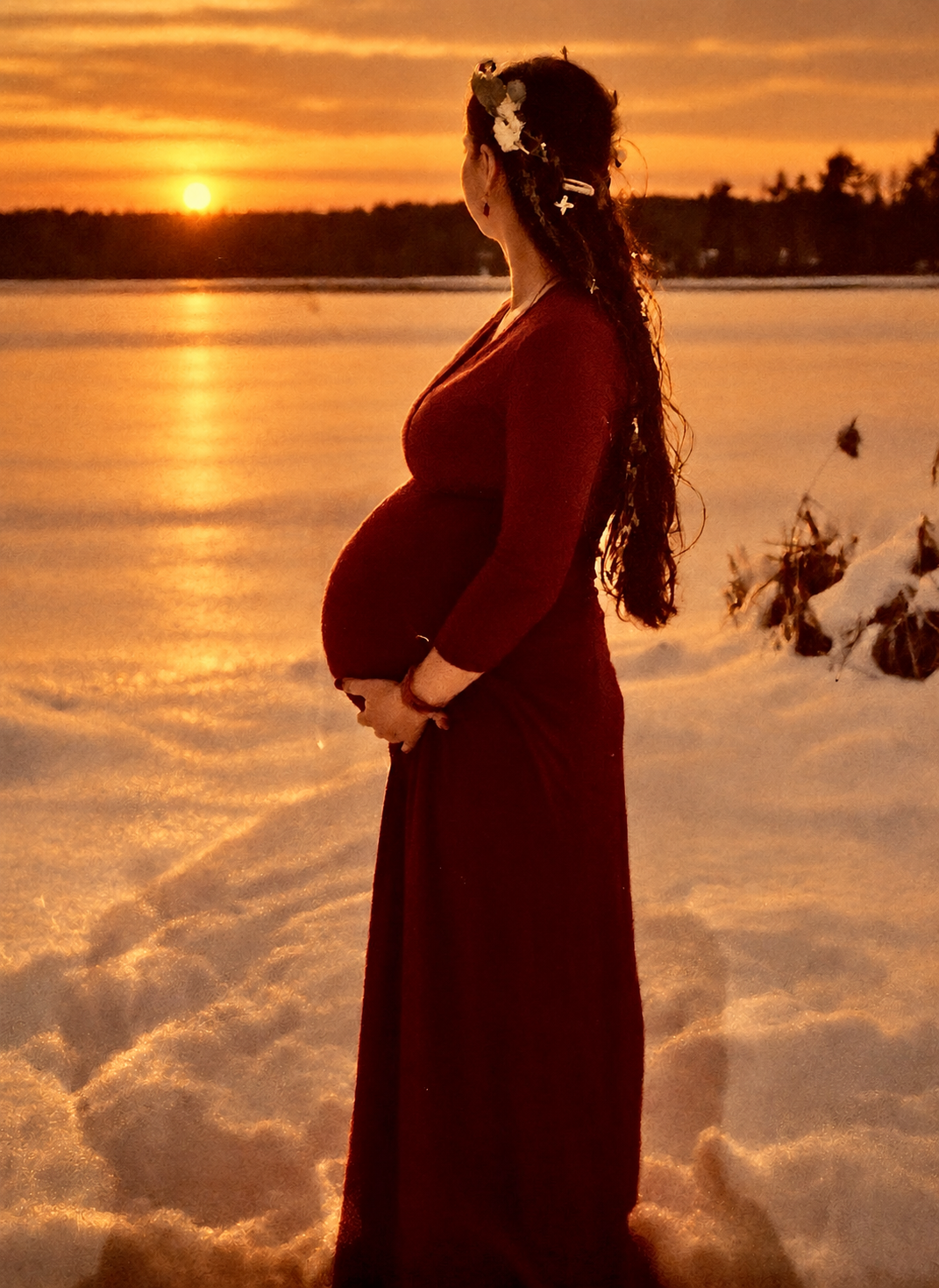 Pregnant woman beside the water at sunset